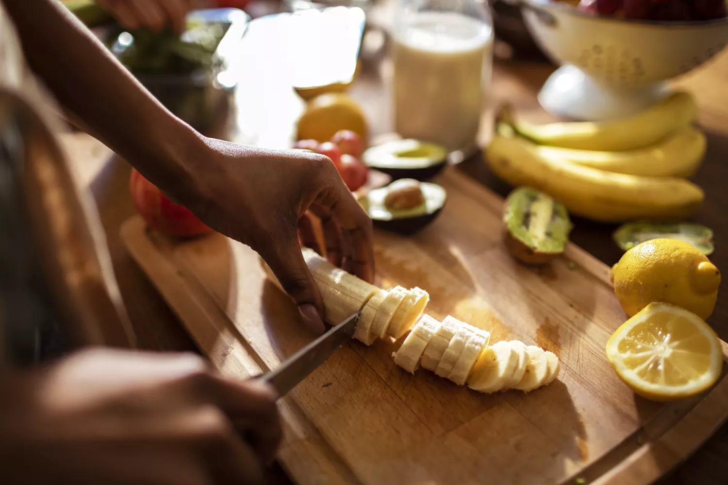 A person cutting bananas on a cutting board